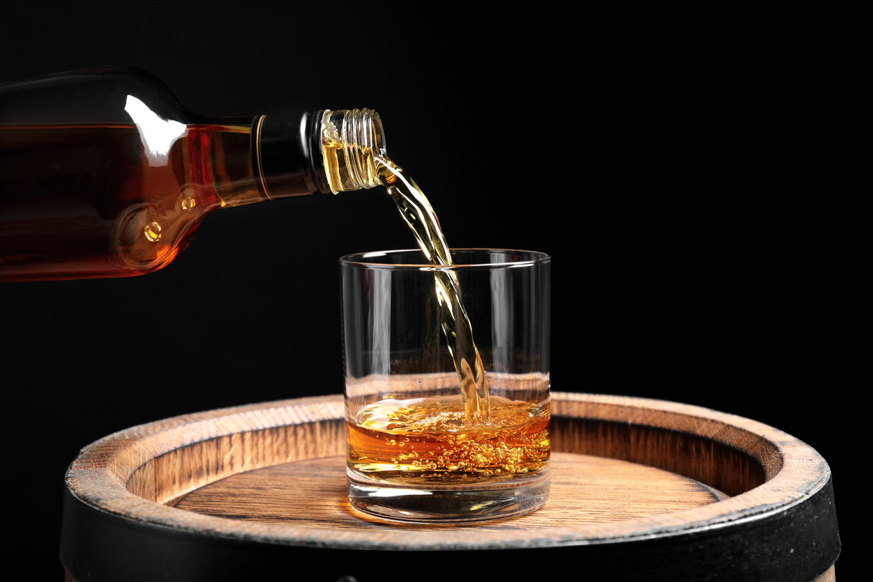bourbon glass on a barrel